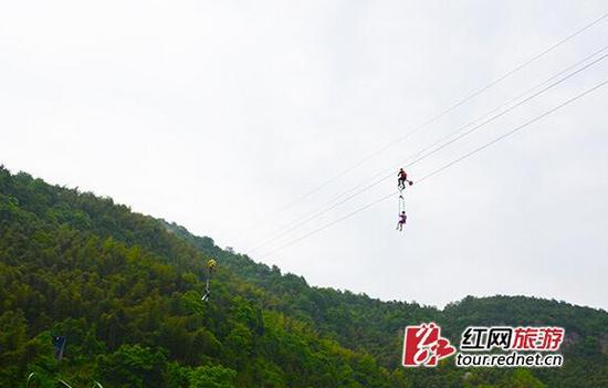 宁乡龙泉大峡谷的高空自行车项目，操作方式为一人在上制动自行车，带动另一搭乘在座椅上的人前进。杨烊图