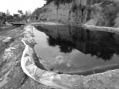 志丹县一处油井旁，污染的石油就随意放在一个池子里。京华时报记者谭青摄
