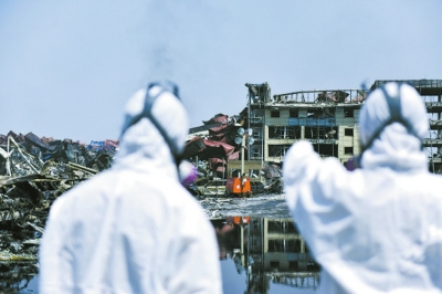 8月16日，电力应急抢险人员身穿防护服进入爆炸事故核心区维护检修照明设备，确保夜间核心区抢险照明