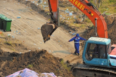 救援人员正在挖土填埋危化品。