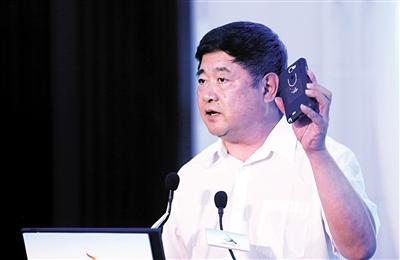 昨日,在2015文化创意产业(北京)研讨会上,故宫博物院院长单霁翔谈故宫文化资源的创意开发,展示自己的手机壳。新京报记者 薛珺 摄