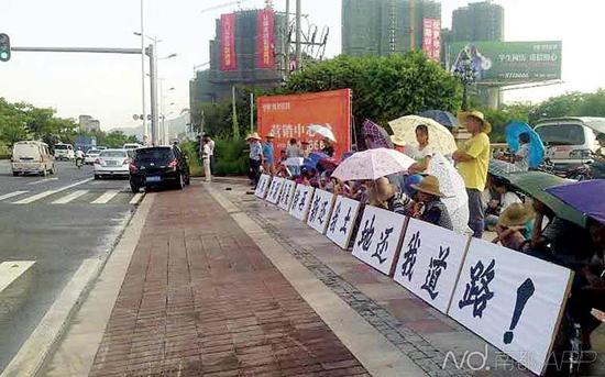 维拉庄园遭邻村村民举牌喊话，“请求原副县长许再新还我土地。”南都记者 张广军 摄