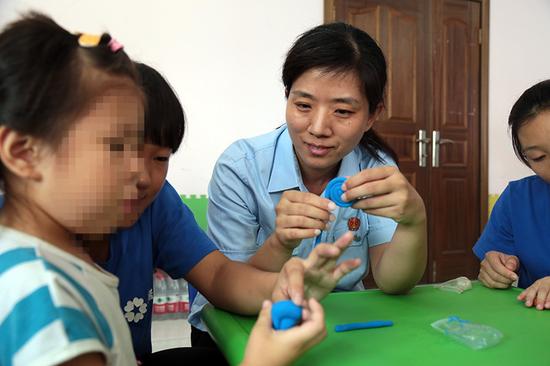 法官、志愿者和孩子們一起進行創作彩色橡皮泥