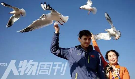2014年12月25日，云南昆明，宁泽涛和教练叶瑾在海埂大坝喂海鸥