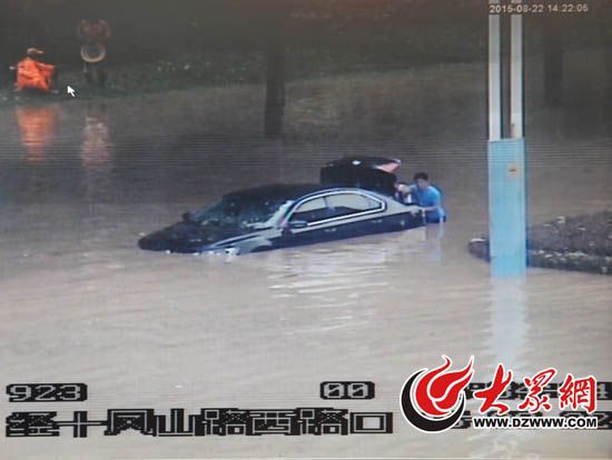 经十凤山路口积水超过半米，一辆轿车抛锚等待救援。