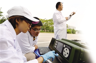 境监测中心的工作人员携带便携式气象监测仪