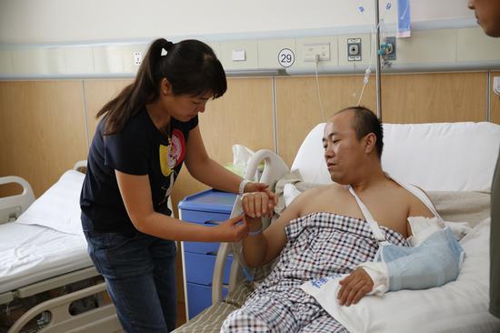 爱人在照顾牛继文。他爱人调侃说牛继文是“硬汉”,受伤、手术后都说“不疼”。 28日,面对吸毒后“精神亢奋”“能量爆棚”“挥刀乱砍”的毒贩,太原公安刑警牛继文和他的5个小伙伴们血染衣襟。制服歹徒后牛继文才发觉尖刀刺入骨头,手术后醒来还交代要“继续抓”毒贩。 (李泽锋 摄)