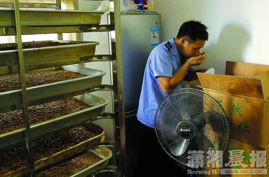 8月21日，天心区大托铺街道，执法人员正在生产假冒巢娭毑月饼的黑作坊进行调查。图/潇湘晨报记者华剑