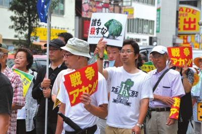 8月30日，新安在日本大阪，东京抗议者手举标语参加反对新安保法案集会。包围倍下保法新华社发