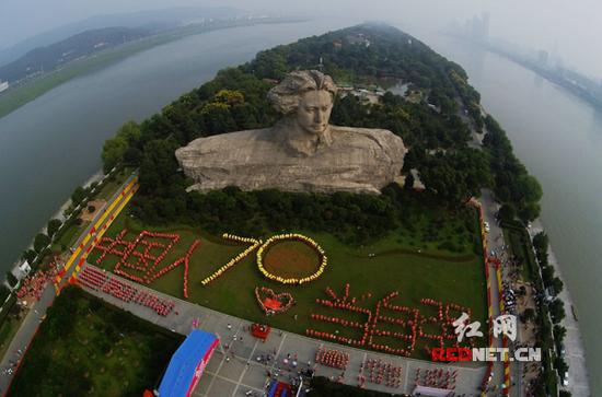 (8月30日上午，长沙橘子洲头青年毛泽东塑像前，近千名市民用人体队形创意拼字，共同构筑大型文字“中国人当自强”，纪念中国人民抗战胜利70周年。杨华峰摄 )