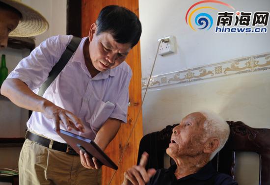 在文昌市抱罗镇抱罗村张修隆家里,邢峰在采访并做记录。