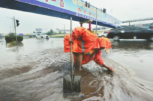 在濟鋼鐵路橋附近，環衛工掏出堵住下水道口的雜物。高歌 攝