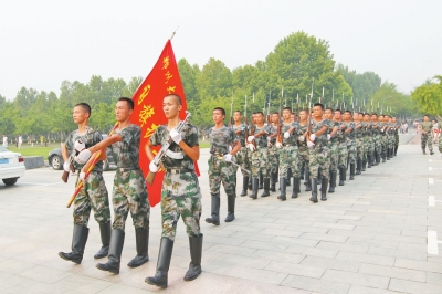 国旗护卫队队员手握着钢枪,气宇轩昂地在校园里走过,十分引人注目。