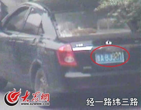 交警發現黑色轎車的車牌被用樹葉擋住，隨即趕赴現場查處