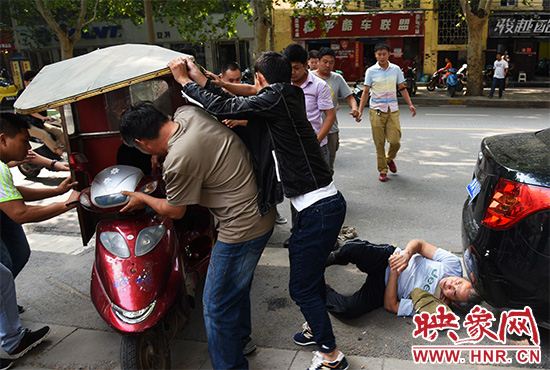 周老汉被压在车下,附近路人纷纷赶来帮忙抬车救人。