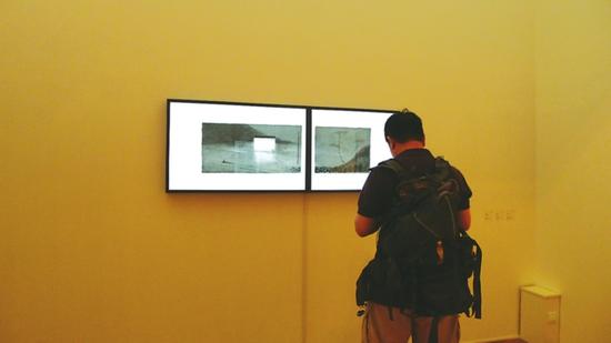 一名摄影记者在苏州博物馆　沈勤个展现场。