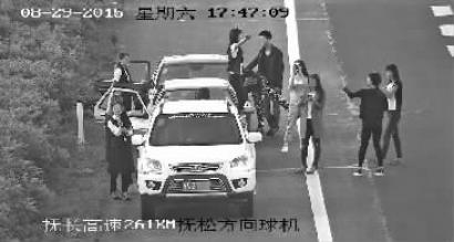 数名年轻人高速公路上违停