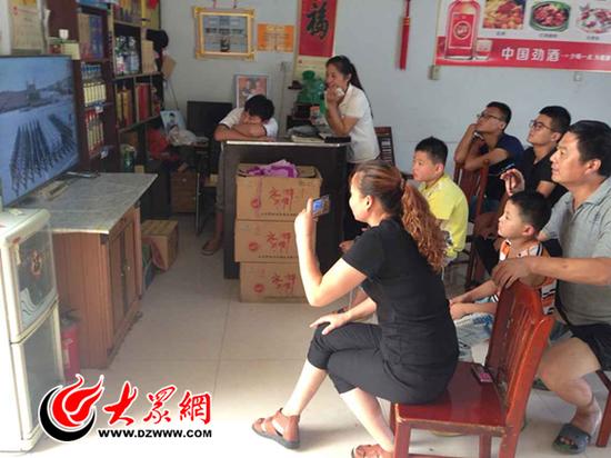 李玉晨的家人在餐館里一同觀看大閱兵