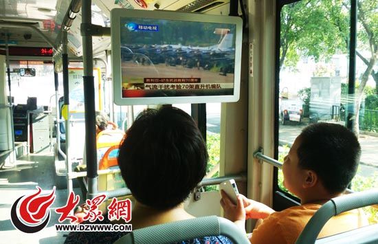 濟南66路公交車上，市民通過車載電視觀看閱兵式