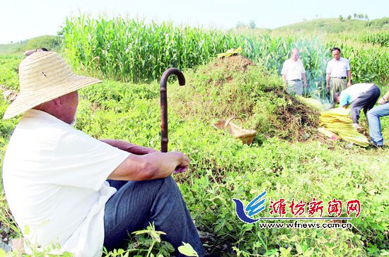 牛余慶(左)注視著張維吉的后人拜祭。