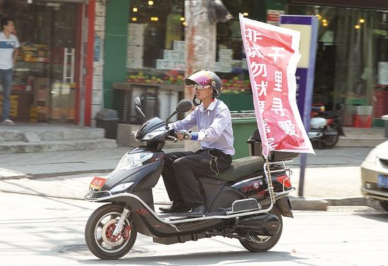 图为：男子骑行经过武汉