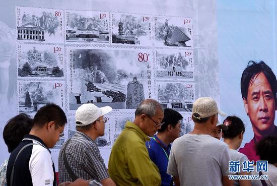 9月3日，在沈阳九一八历史博物馆广场上展出的纪念邮票展板前，市民排队等待邮票设计者李晨签名。