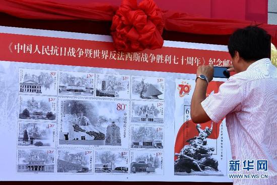 9月3日，市民在沈阳九一八历史博物馆广场上展出的纪念邮票展板前拍照。