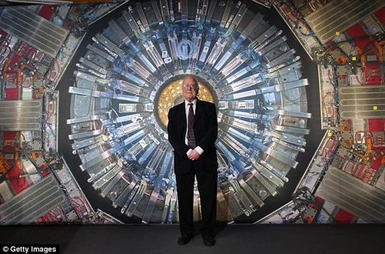 在伦敦举行的“科学博物馆对撞机展览”期间，皮特·希格斯教授站在一幅大型强子对撞机的照片前。近日，利用这台世界上最强大的粒子对撞设备，科学家们大大加深了我们对于希格斯粒子的理解