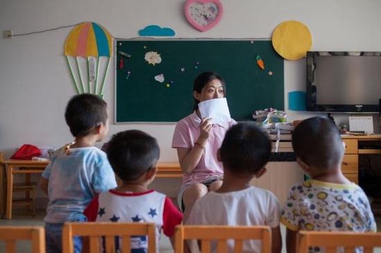 彭晓雯挡住嘴点名,测试孩子们的助听设备是否工作正常(9月7日摄)