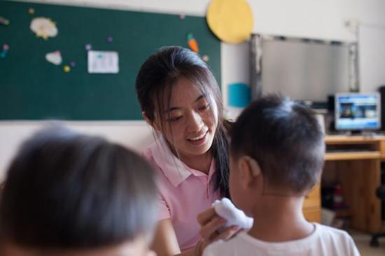 彭晓雯为刚吃过午饭的小朋友擦嘴(9月7日摄)。