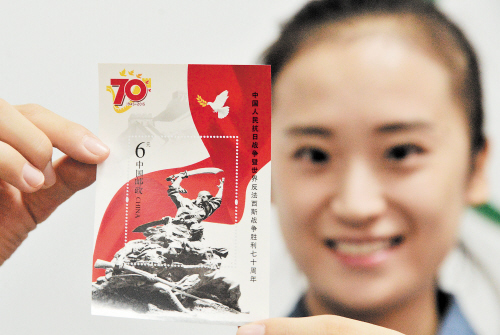 　9月3日，中国邮政发行《中国人民抗日战争暨世界反法西斯战争胜利七十周年》纪念邮票1套13枚，小型张1枚，全套邮票面值20.80元。图为一名集邮爱好者展示相关小型张。 IC 供图