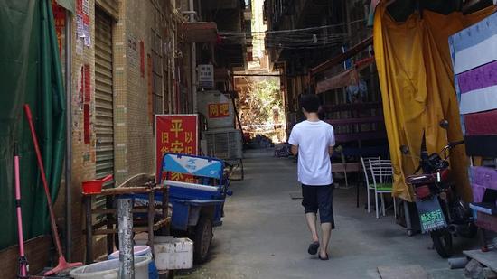 仅可容两人错身的窄小夹道，在它两边是两栋十多层高的宿舍楼。