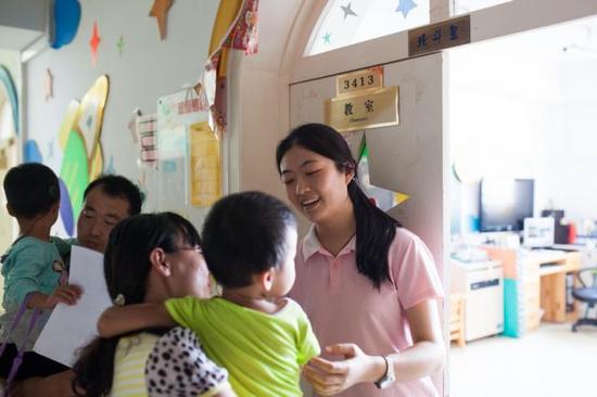 彭晓雯接收新入园的小朋友(9月7日摄)。