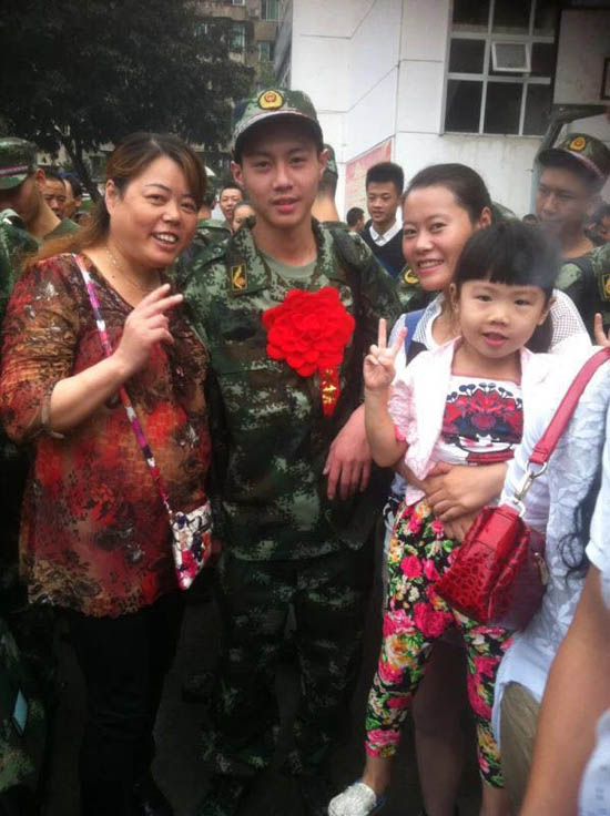 未满18岁的四川男孩袁海去年到天津当消防兵，姐姐袁媛（右二）为他戴上大红花。
