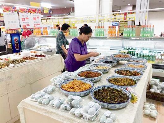 图为:市民在超市选购熟食制品