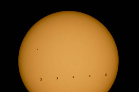 这张合成图片显示了2015年9月6日，国际空间站掠过太阳时留下的5个轮廓。原始图片在美国弗吉尼亚州仙纳度国家公园拍摄。