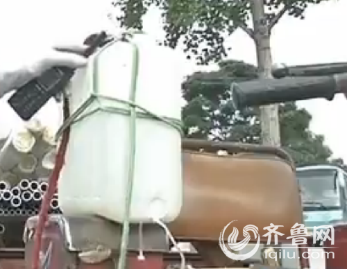 這輛三輪車由于年代已久,發動機散熱片不起作用了,駕駛員擔心高溫下發動機會“中暑”,就“打吊瓶”降溫。(視頻截圖)