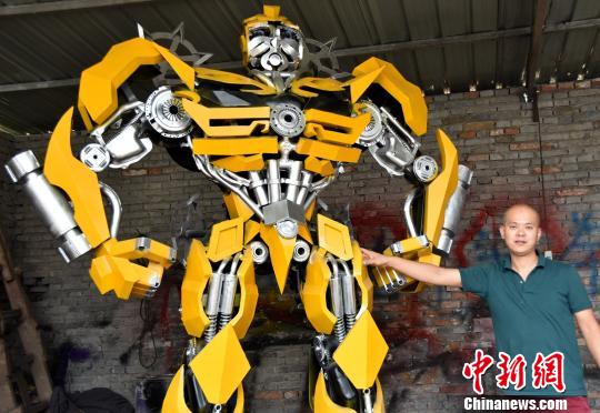 圖為王振利用20多噸的廢棄汽車材料制作的高達16米的“擎天柱”。　司林　攝