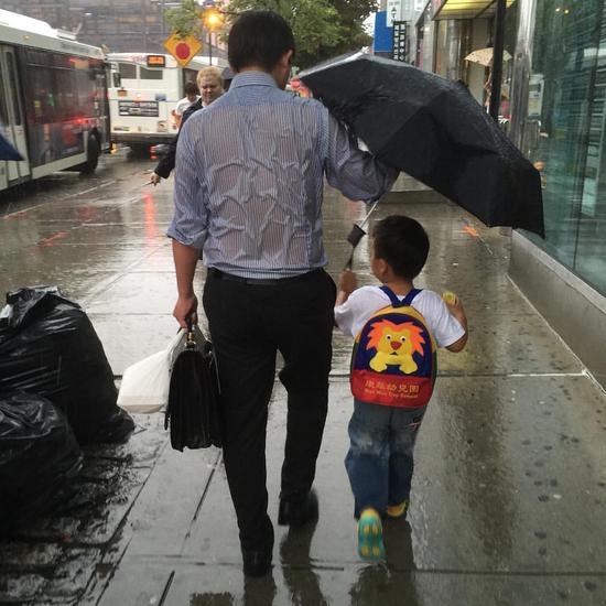 爸爸为儿子撑伞照片感动无数人