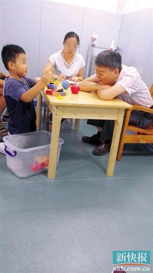 ■邹小兵(右)在与患儿交流。