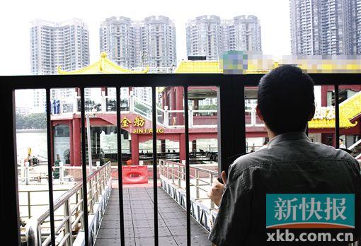 ■一名保安隔着防护栏望向出事的游船。