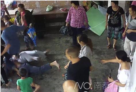 上前阻止的学校书记刘昌明摔倒后,打人家长的舅子还踹了他一脚。监控视频截图