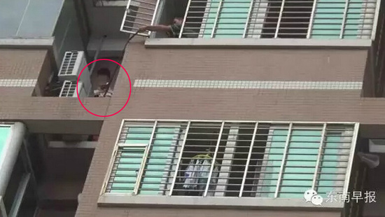 男子挂在阳台外