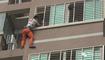 男子挂在阳台外