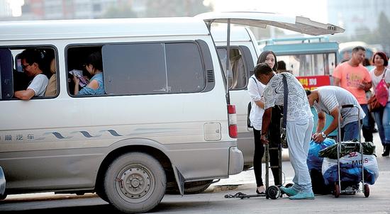 京广路航海路口东侧，一辆黑车里塞着14个人。