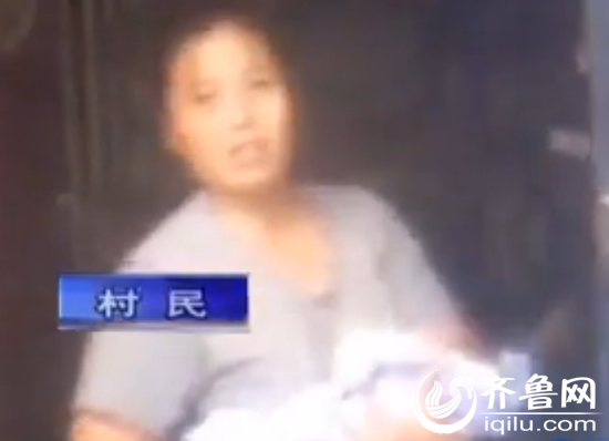 村民手中抱着弃婴向记者讲述当时的情况(视频截图)