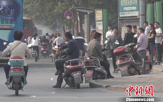 在郑州市主要路段的公交站台附近,揽客的电摩依然存在。 李超庆 摄