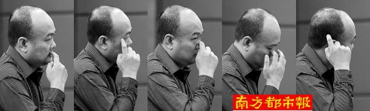 “坟爷”在接受庭审时，表情轻松，手部不时做出各种动作。