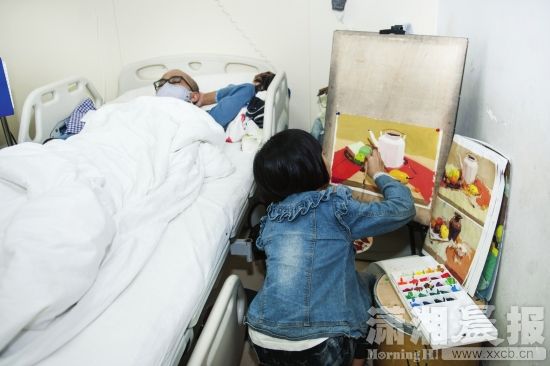 9月19日，湘雅医院，8岁小女孩在爸爸的病床旁画画，她想卖画给爸爸筹钱治病。