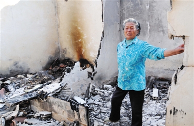 16日，死者张纪民的亲戚在被烧毁的房屋内哭泣。 新华社记者 周科 摄